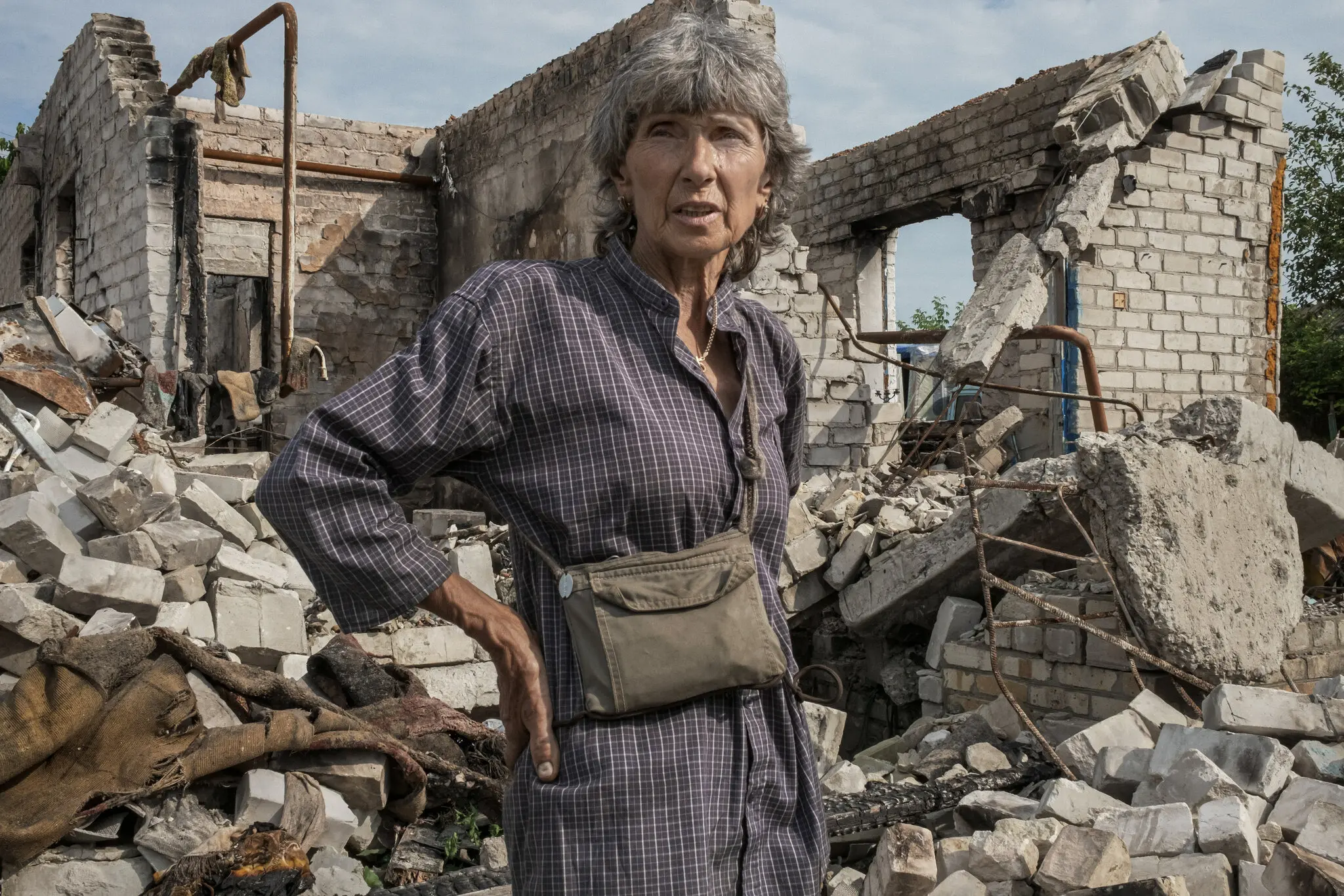 60-річна Світлана Спорник зупиняється, оглядаючи руїни свого будинку в Кам’янці
